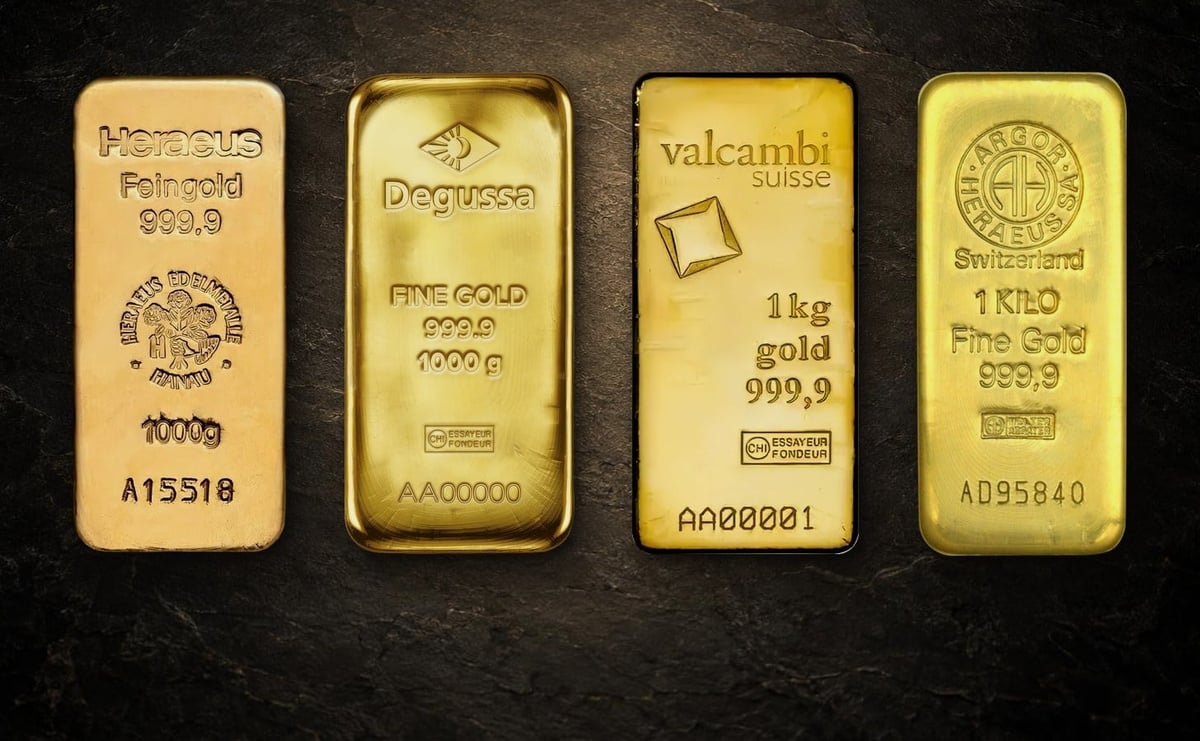 Vier Kilobarren nebeneinander auf dunklem Stein, von links Heraeus, Degussa, Valcambi und Argor‑Heraeus, jeder mit Gewicht und 999,9 gestempelt