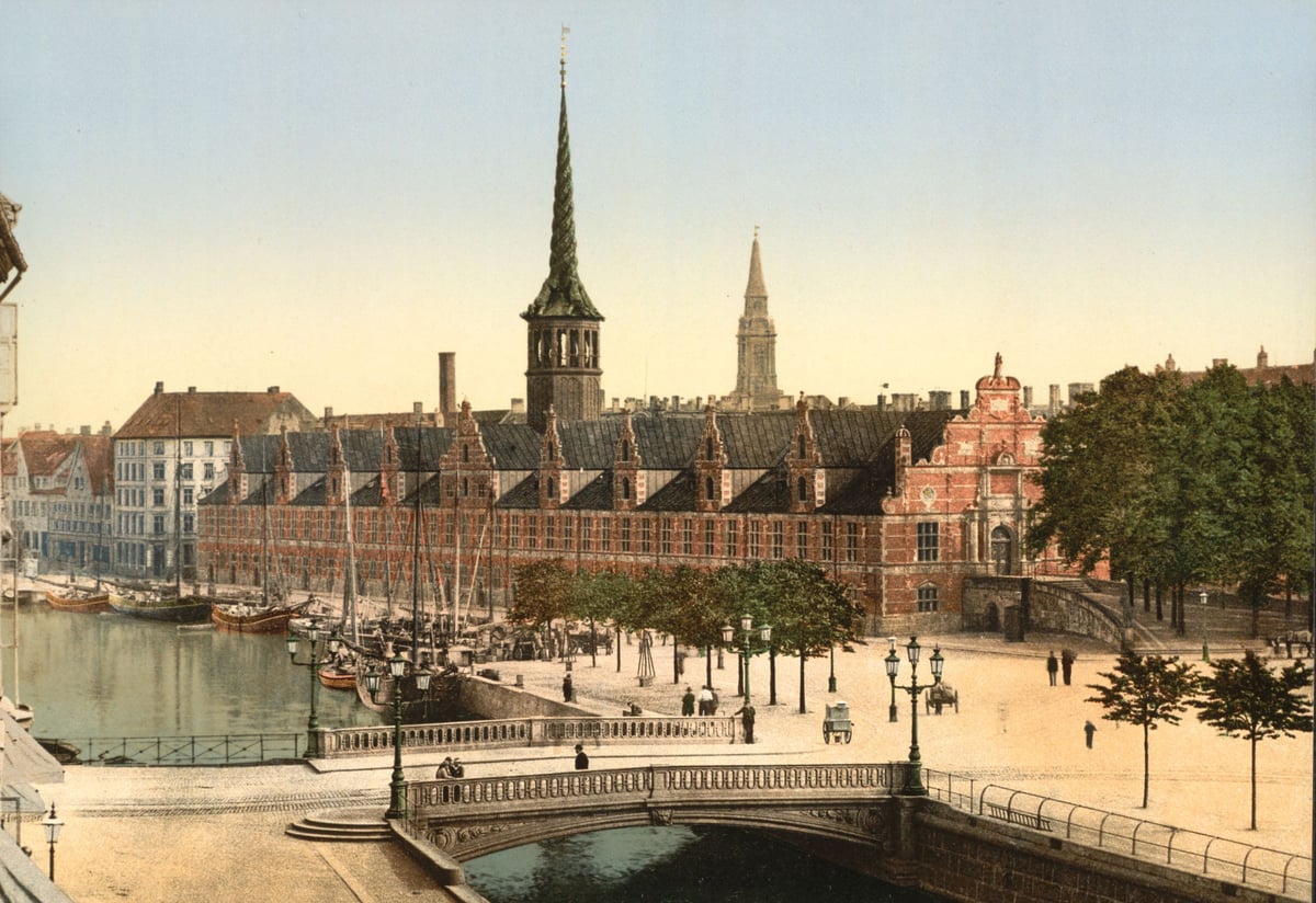 Kopenhagen zwischen 1890 und 1900: die Börse mit ihrem gedrehten Turm am Kanal, davor Segelschiffe, eine Brücke und ein weiter Platz
