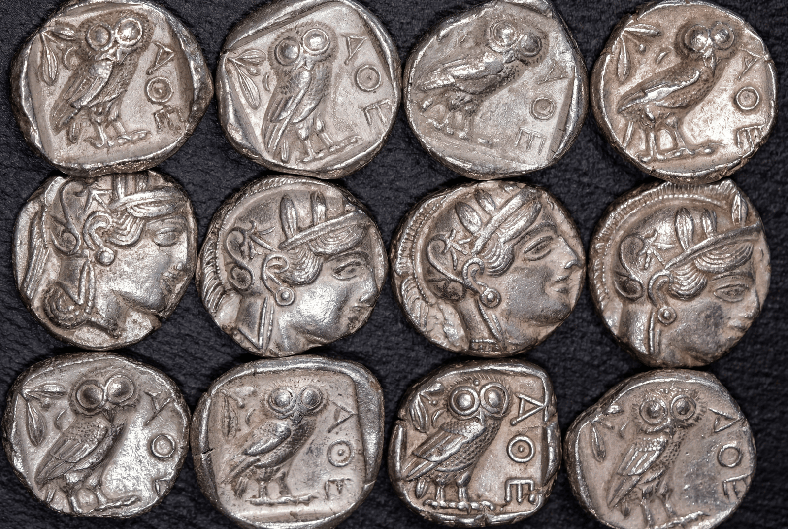 Zwölf Athener Tetradrachmen in drei Reihen: oben und unten je vier mit der Eule, in der Mitte vier mit dem Kopf der Athena