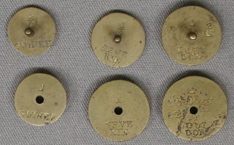 Sechs runde Messinggewichte mit eingeschlagenen Münznamen: GUINEE, SEVERIN, LOUIS DOR sowie DOPPIEN ET LOUIS DOR, dazu Zahlen wie 1 und 2