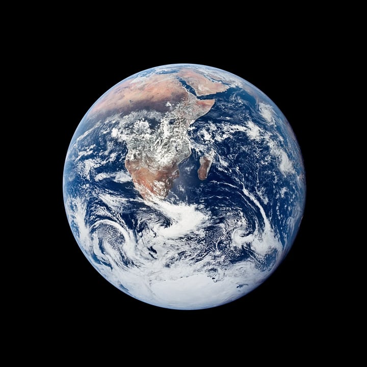 The whole Earth as a globe against black, with Africa, Arabia and Antarctica beneath white clouds